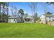 Wide shot of a large backyard with well-maintained lawn and home and garage at 4217 Royal Harbor Rd, Hollywood, SC 29449