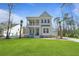Inviting two-story home featuring a spacious lawn, palm trees, and a double front porch at 4217 Royal Harbor Rd, Hollywood, SC 29449
