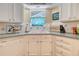 Charming kitchen sink with white cabinetry, tile backsplash, and a bright window at 433 Double Eagle Trace, Seabrook Island, SC 29455