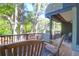 Relaxing back porch with wooden rocking chairs overlooking lush green trees and landscaped yard at 4901 Green Dolphin Way, Kiawah Island, SC 29455