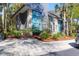 Modern two-story home with blue and gray exterior paint, complemented by palm trees and a driveway with parking at 4901 Green Dolphin Way, Kiawah Island, SC 29455