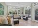 Bright and inviting sun room features large windows, cozy furniture, and a ceiling fan at 4901 Green Dolphin Way, Kiawah Island, SC 29455