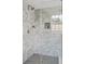 Elegant shower with light gray square tile, black mosaic flooring, and a glass enclosure at 5 Alexander St, Charleston, SC 29401