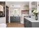 Dual sink bathroom with gray cabinets, marble countertops, and wood floors at 5 Alexander St, Charleston, SC 29401