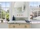 Bright bathroom features white marbled countertop vanity with a view to the outside through two windows at 5 Alexander St, Charleston, SC 29401