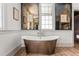 Bathroom showcasing a freestanding tub, shiplap walls, and wood flooring at 5 Alexander St, Charleston, SC 29401