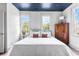 Cozy bedroom with a white comforter, blue ceiling, and bright windows at 5 Alexander St, Charleston, SC 29401
