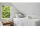 Cozy bedroom with white linens, a patterned rug and tree views from the window at 5 Alexander St, Charleston, SC 29401