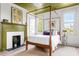 Comfortable bedroom with a four-poster bed, fireplace, and large windows at 5 Alexander St, Charleston, SC 29401
