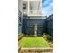 Landscaped courtyard area with artificial turf, a stone water feature and blue wooden fence at 5 Alexander St, Charleston, SC 29401