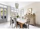 Cozy dining room with a rustic table, elegant chandelier, and views to the garden at 5 Alexander St, Charleston, SC 29401