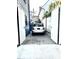 Rear driveway featuring gravel, a parked SUV, and bordering buildings with white and blue fencing at 5 Alexander St, Charleston, SC 29401