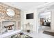 Bright living room featuring a brick fireplace, gold mirror, and entry to the kitchen at 5 Alexander St, Charleston, SC 29401