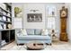 Bright living room with a light blue sofa, hardwood floors, and built-in bookshelves at 5 Alexander St, Charleston, SC 29401