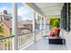 Relaxing porch with white columns and a comfortable red chair and table at 5 Alexander St, Charleston, SC 29401