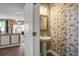 Elegant half bathroom featuring a pedestal sink, statement mirror, and decorative wallpaper at 509 Nadir Ct, Summerville, SC 29486