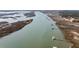 Picturesque aerial view of a river inlet featuring boats, private docks, and marshlands surrounded by natural landscape at 6021 Jibe Ct, Awendaw, SC 29429