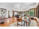 Bright dining room opens to the kitchen, showcasing wood floors and many wood-framed windows at 6021 Jibe Ct, Awendaw, SC 29429