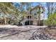 Charming three-story home with a welcoming front porch, manicured landscaping, and a spacious driveway at 6021 Jibe Ct, Awendaw, SC 29429