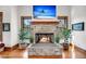 Close-up of a stone fireplace with a mantel, decorative plants, and a mounted television above at 6021 Jibe Ct, Awendaw, SC 29429