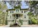 Inviting exterior of home featuring double garages, palm trees, and a staircase to a welcoming front porch at 6021 Jibe Ct, Awendaw, SC 29429