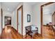 Bright hallway with hardwood floors, a wooden bench, and a glimpse into a well-lit dining area at 6021 Jibe Ct, Awendaw, SC 29429