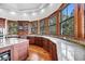 Beautiful kitchen with wood cabinetry, granite countertops, stainless steel sink, and views from surrounding windows at 6021 Jibe Ct, Awendaw, SC 29429