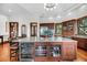 Kitchen island includes wine fridge and abundant storage, with granite countertop and wood floors at 6021 Jibe Ct, Awendaw, SC 29429