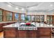 Kitchen island with cooktop in a spacious kitchen features wood floors, windows, and granite countertops at 6021 Jibe Ct, Awendaw, SC 29429