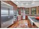 Bright kitchen with stainless steel appliances, wood floors, and wood framed windows overlooking trees at 6021 Jibe Ct, Awendaw, SC 29429
