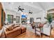 Spacious living room with a stone fireplace, leather seating, and large windows for ample natural light at 6021 Jibe Ct, Awendaw, SC 29429