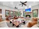 Comfortable living room with a stone fireplace, leather seating, and plenty of natural light from the windows at 6021 Jibe Ct, Awendaw, SC 29429