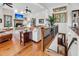 Open-concept living room boasts a stone fireplace, wood floors, and many windows allowing ample natural light at 6021 Jibe Ct, Awendaw, SC 29429