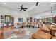 Open-concept living room featuring hardwood floors, neutral furnishings, and a glimpse of the dining area at 6021 Jibe Ct, Awendaw, SC 29429