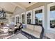 Covered porch with comfortable seating arrangement and outdoor lighting at 6021 Jibe Ct, Awendaw, SC 29429