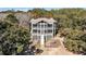 An aerial view of the rear of a home with multiple screened porches and a lush backyard at 6021 Jibe Ct, Awendaw, SC 29429
