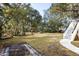 Expansive backyard with lush lawn, framed by mature trees and featuring a charming staircase leading to the home at 669 Palisades Dr, Mount Pleasant, SC 29464