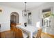 Elegant dining room showcasing a stylish light fixture, hardwood floors, and light-filled windows with plantation shutters at 669 Palisades Dr, Mount Pleasant, SC 29464