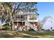 Charming multi-story home featuring a screened porch and elevated deck, surrounded by lush greenery and a well-maintained lawn at 669 Palisades Dr, Mount Pleasant, SC 29464