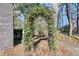 Arched entry framed by trees and climbing plants leads to the lush and serene backyard at 905 Battery Way, Mount Pleasant, SC 29464