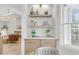 Stylish bar area featuring floating shelves and views to the living area with a modern chandelier at 905 Battery Way, Mount Pleasant, SC 29464