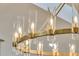 Close-up of a stylish, modern chandelier with cylindrical glass shades and sleek gold hardware at 905 Battery Way, Mount Pleasant, SC 29464
