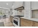 Gas range stove with a wooden range hood and white and wood cabinets at 905 Battery Way, Mount Pleasant, SC 29464