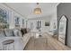 Bright living room with a neutral color palette, floor-to-ceiling windows, and a modern chandelier at 905 Battery Way, Mount Pleasant, SC 29464