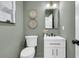 Charming powder room with light green walls, decorative wall baskets, and a modern mirror at 905 Battery Way, Mount Pleasant, SC 29464