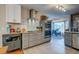 Eat-in kitchen shows modern gray cabinetry, subway tile, stainless appliances, granite counters and view to sunroom at 960 Mooring Dr, Charleston, SC 29412