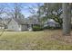 View of the home's backyard, featuring a screened porch and mature trees at 105 Gatewood St, North Charleston, SC 29418