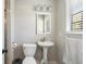 Cozy bathroom featuring a pedestal sink, white fixtures, and natural light from the window at 112 Blue Heron Dr, Summerville, SC 29485