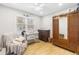Bedroom with hardwood floors, a dark wood armoire, a crib, and a comfortable chair at 112 Blue Heron Dr, Summerville, SC 29485