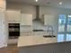 Bright kitchen with stainless steel appliances, quartz countertops, and a stylish range hood over the cooktop at 1146 Darling St, Summerville, SC 29485